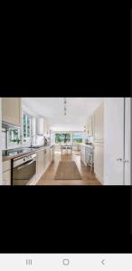 a kitchen with white cabinets and a table in it at Hytte ved elv in Hektner