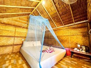 a bed in a room with a mosquito net at Check in Lanta in Ko Lanta