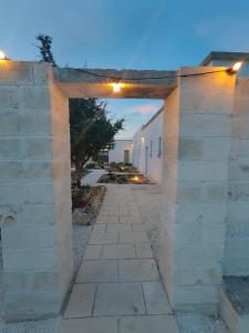un arco in un muro di mattoni con un sentiero di Tenuta Sofia a Otranto