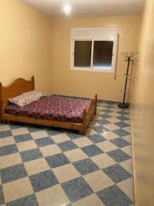 1 dormitorio con 1 cama y suelo a cuadros en Ras El Ma Center Family Appartment, en El Borj