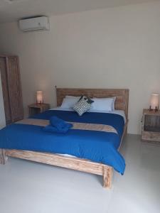 een slaapkamer met een groot bed met blauwe lakens bij Hasta La Vista Villa Amed in Amed