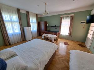 a bedroom with two beds and a table and a kitchen at Eagles Court - Orlovski Vrt in Staji°evo