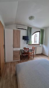 a room with a bed and a table and chairs at Apartmani Ritoša in Novigrad Istria
