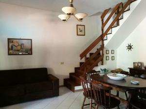 uma sala de estar com um sofá, uma mesa e uma escada em Villa c/Piscina 100mt dal mare Roma G em Marina di San Nicola