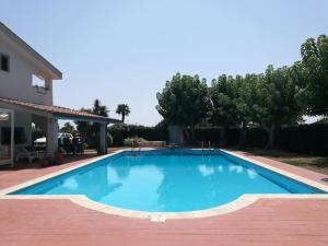 uma grande piscina azul ao lado de uma casa em Villa c/Piscina 100mt dal mare Roma G em Marina di San Nicola