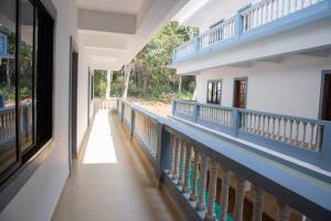 an empty hallway of a building with blue railing at DE 28:11 GUEST HOUSE in Mapusa