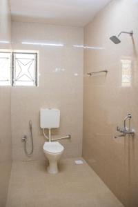 a bathroom with a toilet and a shower at DE 28:11 GUEST HOUSE in Mapusa