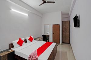 a bedroom with a large bed with red pillows at OYO Hotel Grand Shiva in Noida