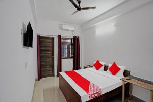 a bedroom with a bed with red pillows on it at OYO Hotel Grand Shiva in Noida