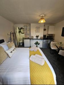 a bedroom with a large bed with towels on it at Stylish Studio Stevenage in Stevenage
