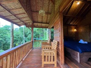 a cabin with a bed and chairs on a deck at Serenity Lodge Tetebatu Lombok in Tetebatu +49 photos
