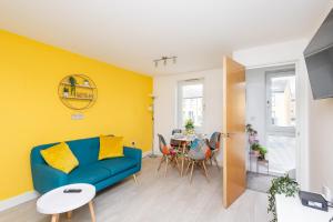 a living room with a blue couch and a table at Wakefield Centre - Westgate Station - Off Road Parking, Self Check-in, Fast Wi-Fi - Families, Contractors, Long Stays in Wakefield