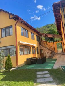 - un bâtiment jaune avec une terrasse en face dans l'établissement Casa Roșca, 