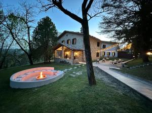 a house with a fire pit in the yard at Agriturismo Akasha in Branca