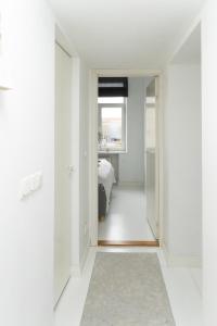 um corredor com paredes brancas e um quarto com uma cama em City Center Maakri Apartment em Talin