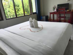 dois bichos de peluche sentados em cima de uma cama em Dokchampa Hotel em Vang Vieng