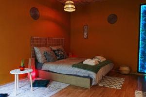 a bedroom with a bed with an orange wall at Sahara studio with shared bathroom in city centre in Bratislava