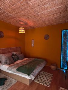 a bedroom with a bed in a yellow wall at Sahara studio with shared bathroom in city centre in Bratislava