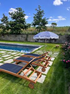 a group of lounge chairs next to a swimming pool at Domaine du tertre ychot in Dol-de-Bretagne