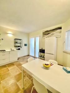 a kitchen with a table with a bowl of fruit on it at Domu Su Neulaghe in Villasimius