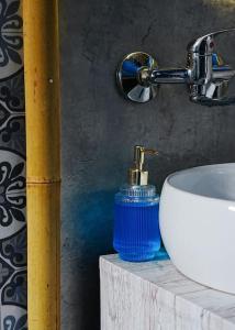 a bathroom with a sink and a blue soap dispenser at Sahara studio with shared bathroom in city centre in Bratislava