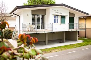 ein kleines weißes Haus mit Balkon auf einer Straße in der Unterkunft Villa Isolda bilocale rilassante in Bibione