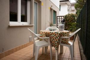 einen Tisch und Stühle auf einem Balkon mit einem Tisch, einem Tisch und Stühlen in der Unterkunft Villa Isolda bilocale rilassante in Bibione