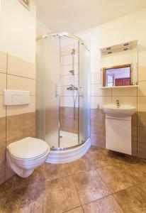 a bathroom with a shower and a toilet and a sink at Ośrodek Wypoczynkowy NA WYDMIE in Dziwnów