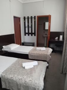 Habitación de hotel con 3 camas y lavamanos en Гостиница "SEMEY-CITY" en Semey