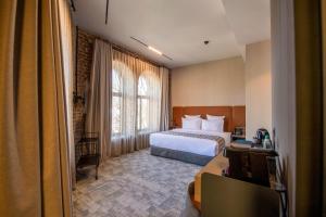 Rúm í herbergi á Qarvasla Hotel