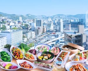 a table filled with bowls of food on top of a city at THE GLOBAL VIEW Nagasaki in Nagasaki