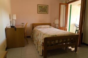a bedroom with a bed and a dresser and a window at Albergo San Lorenzo in Grosseto
