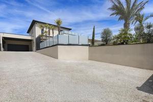 a house with a fence and a driveway at Villa Vice City -proche Eurexpo/Groupama stadium/LDLC Arena in Chamagnieu