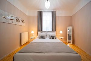 a bedroom with a large bed with two lamps at Oikia Tripodon in Athens