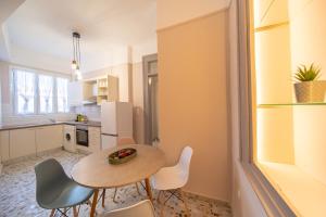 a kitchen and dining room with a table and chairs at Oikia Tripodon in Athens +23 photos