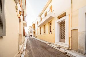 an empty street in an alley between buildings at Oikia Tripodon in Athens