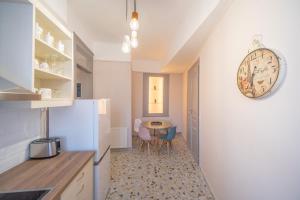 a kitchen with a table and a clock on the wall at Oikia Tripodon in Athens
