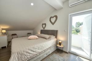 a bedroom with a bed with hearts on the wall at Sunset view New apartment in Cavtat