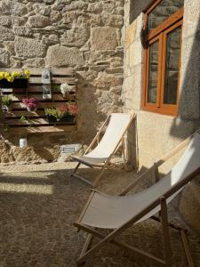 two lawn chairs sitting outside of a building at Casa Dos Ruis - Turismo Rural in Tabuaço