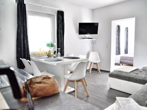 a living room with a white table and chairs at Ground floor apartment with terrace and large garden with lounge area and grill in Mönkebude