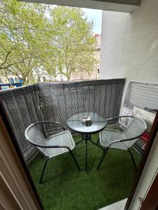 een balkon met een tafel en 2 stoelen op een patio bij L avenir in Clichy
