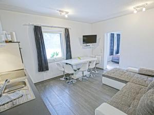 MönkebudeにあるGround floor apartment with terrace and large garden with lounge area and grillのリビングルーム(ベッド1台、テーブル、ソファ付)