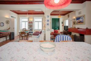 a dining room and living room with a table and chairs at Torreira . Yellow Beach Pavilion in Torreira