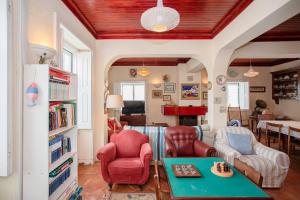 a living room with red chairs and a table at Torreira . Yellow Beach Pavilion in Torreira