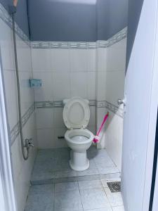 een badkamer met een wit toilet met een roze wand bij Nhà Nghỉ Thành Đạt in Can Tho