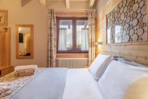 a bedroom with a large bed with a wooden headboard at La Tana dell'orso Hotel & SPA in Ponte di Legno