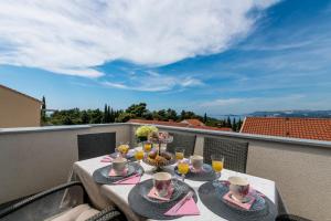a table with food and drinks on a balcony at Sunset view New apartment in Cavtat