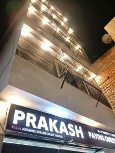 HOTEL PRAKASH GUEST HOUSE ! Varanasi ! fully-Air-Conditioned hotel at prime location with off site Parking availability, near Kashi Vishwanath Temple, and Ganga ghat في فاراناسي: وجود لافتة لصيدلية الببغاء على جانب المبنى