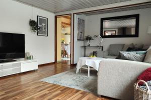 ein Wohnzimmer mit einem Sofa und einem TV in der Unterkunft Hus i Skärhamn när till hav och natur! in Utäng