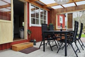 einen schwarzen Tisch und Stühle auf einer Terrasse in der Unterkunft Hus i Skärhamn när till hav och natur! in Utäng